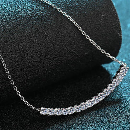 A modern curved bar moissanite necklace set in sterling silver