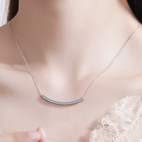 A modern curved bar moissanite necklace set in sterling silver