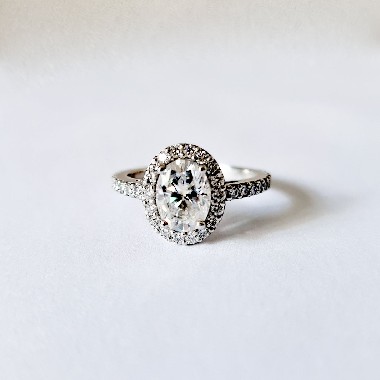 1.5 carat oval halo moissanite engagement ring set in platinum